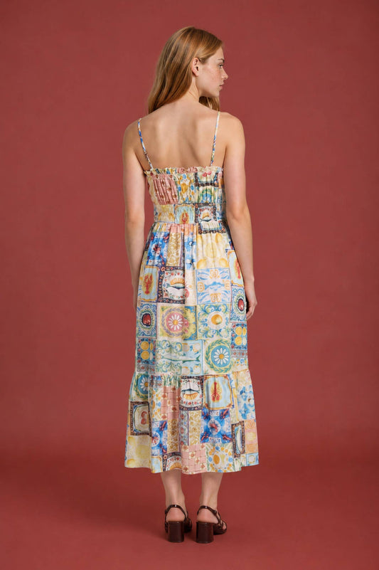 Woman wearing a colorful patchwork dress against a red background